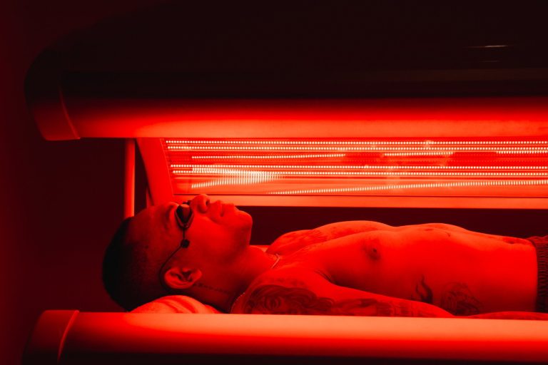 Client relaxing in a red light therapy bed