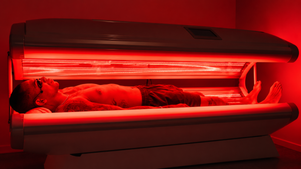 Client relaxing in the full-body red light therapy bed at Healing Waters Wellness